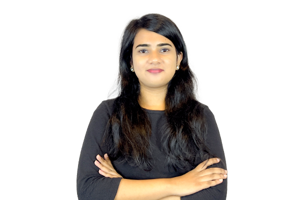Professional woman with long dark hair, wearing a black top, arms crossed, standing against a light background.